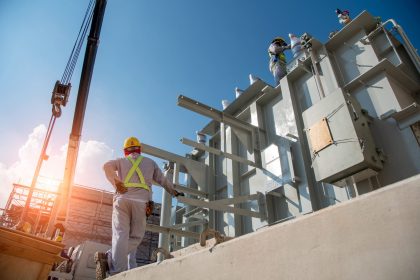 Two workers servicing transformers.